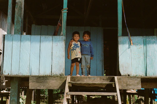 A family embracing naturally on a terracotta-colored rustic porch