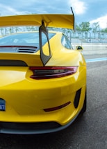 a yellow sports car parked on the side of the road