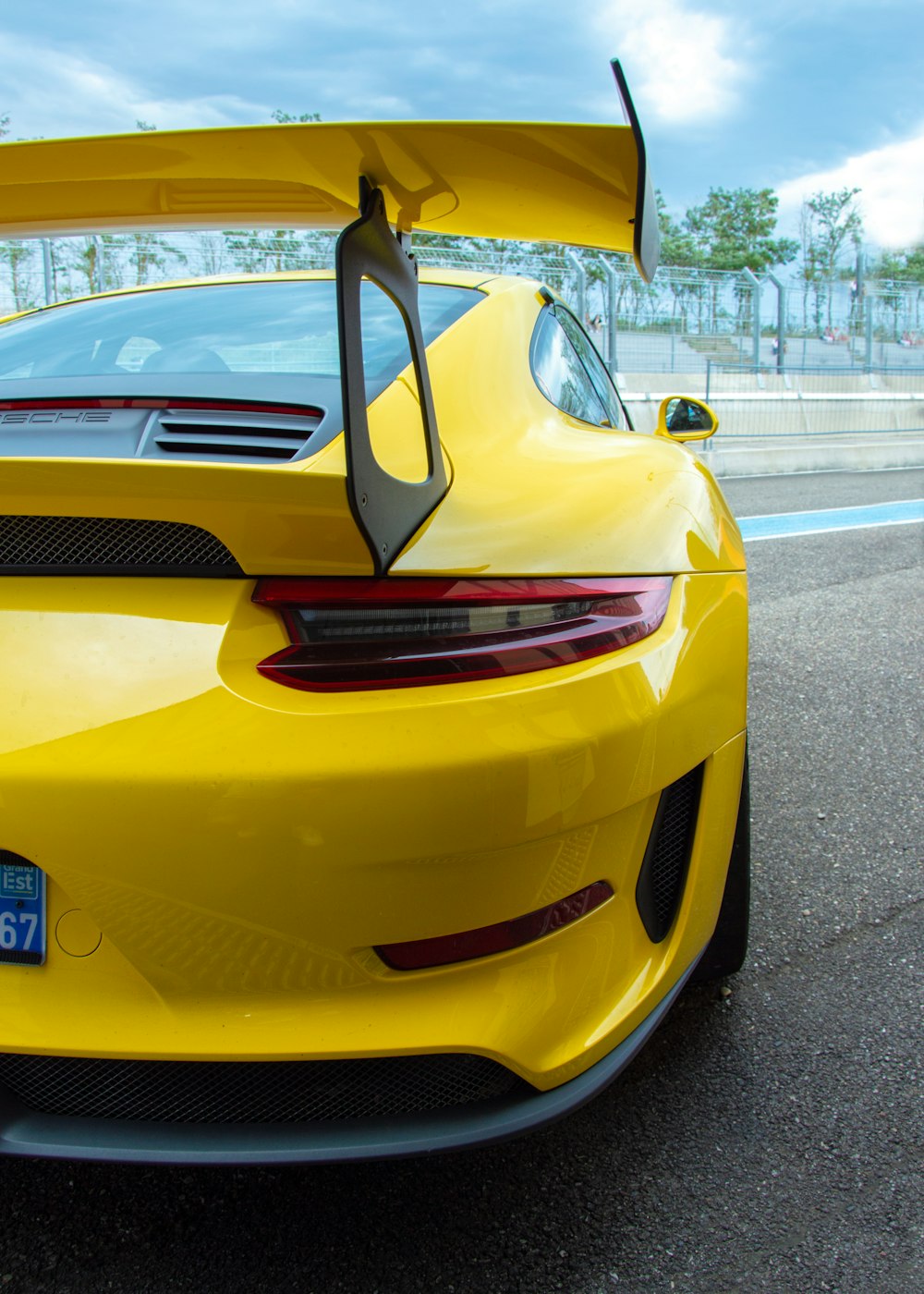 a yellow sports car parked on the side of the road