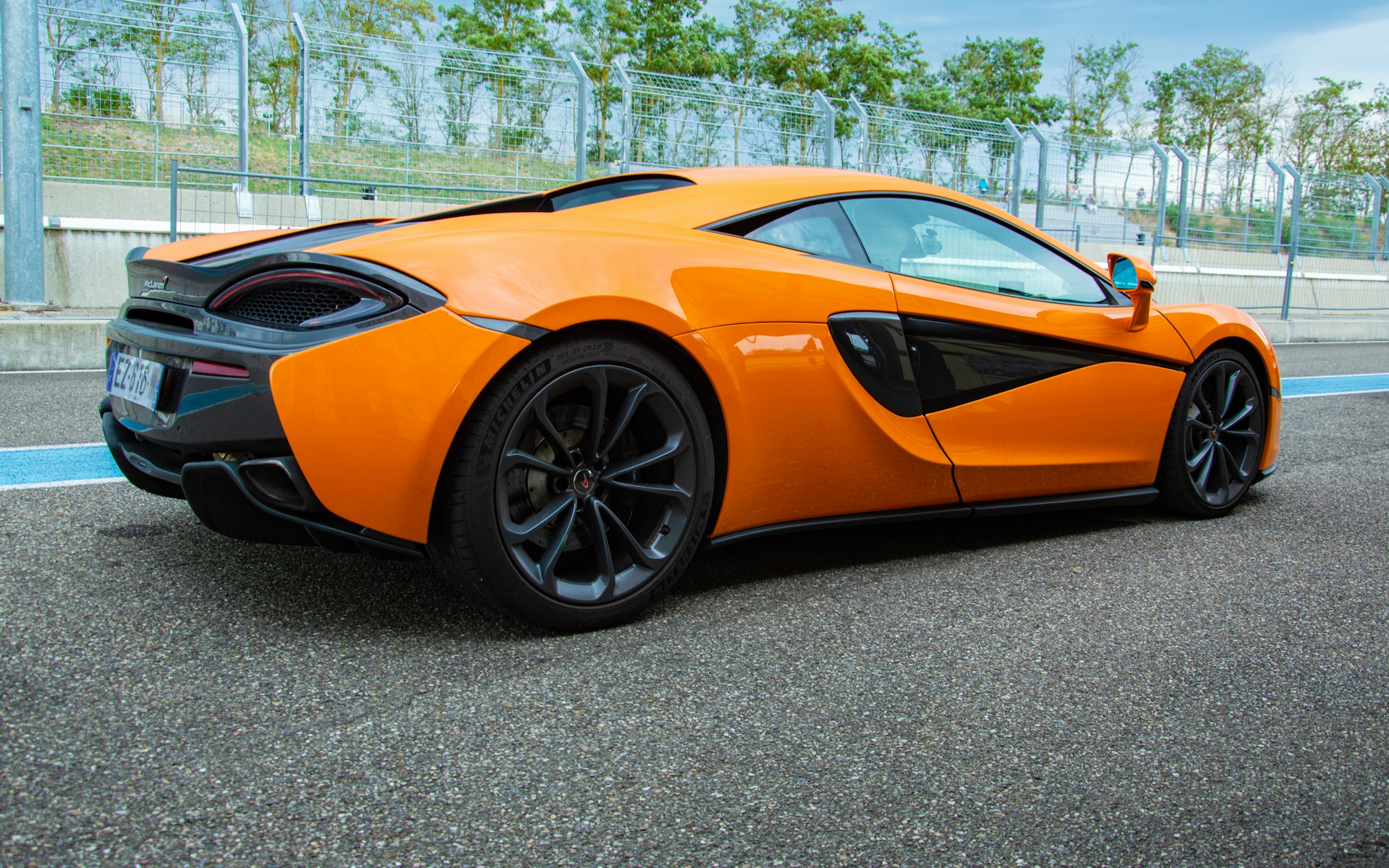 an orange sports car parked in a parking lot