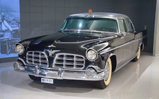 An appraiser examining a custom classic car with polished chrome details.