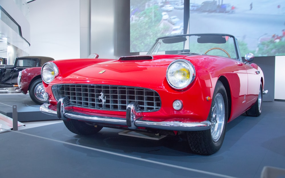 a red sports car is on display in a museum