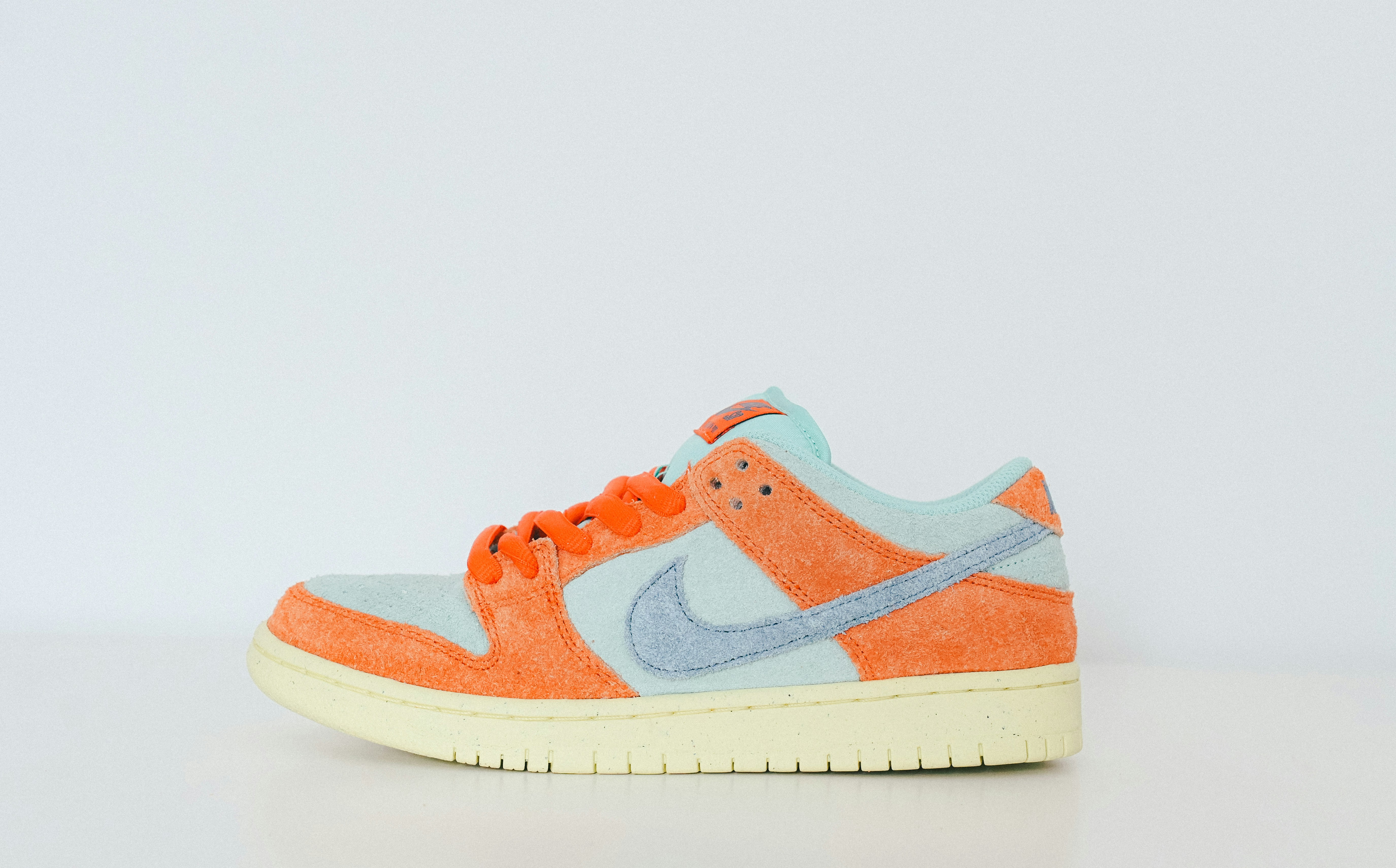 a pair of orange and blue sneakers on a white surface