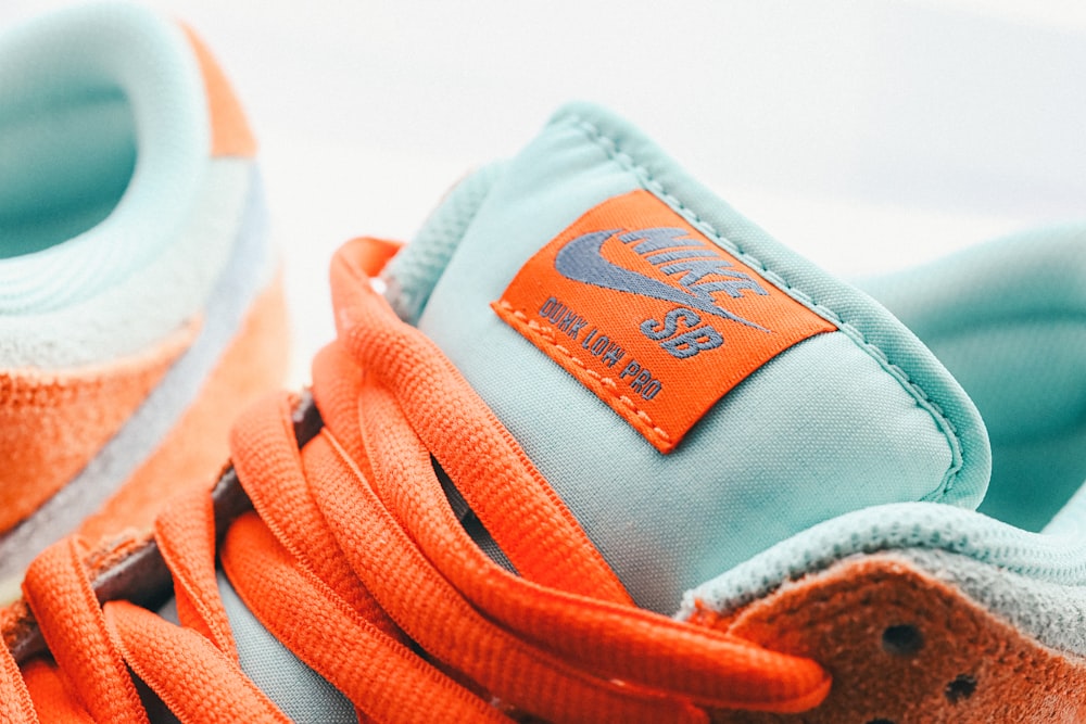 An orange and blue sneaker with a tag on it photo – Free Nike sb Image on  Unsplash