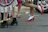 Close-up of a pair of vibrant magenta shoes walking confidently on a city sidewalk.