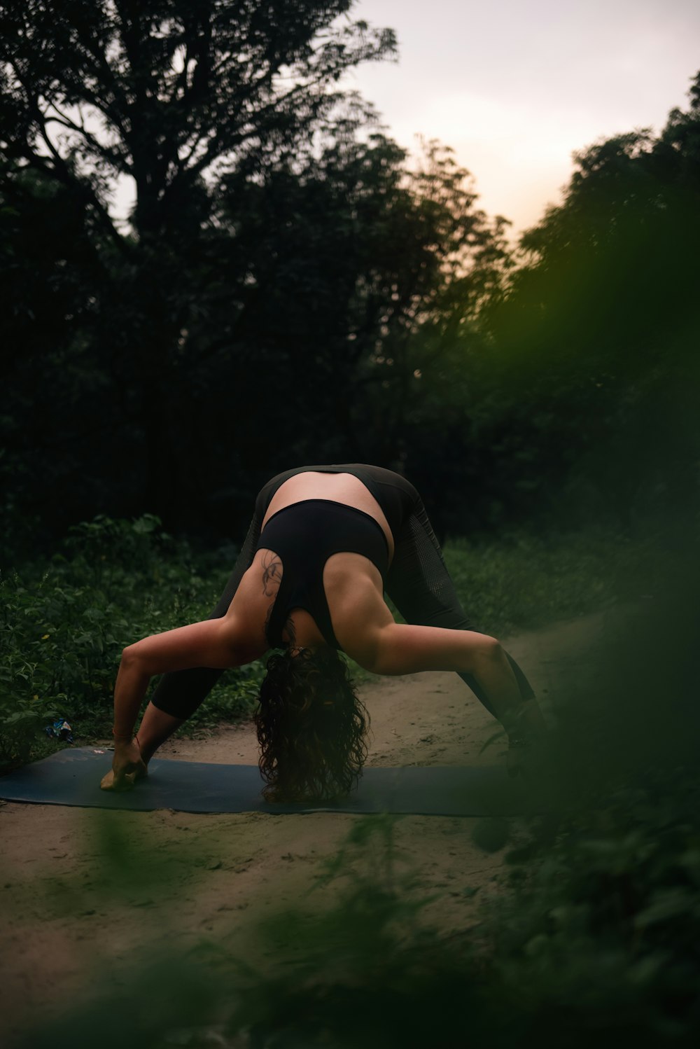 a woman is doing a yoga pose in the woods