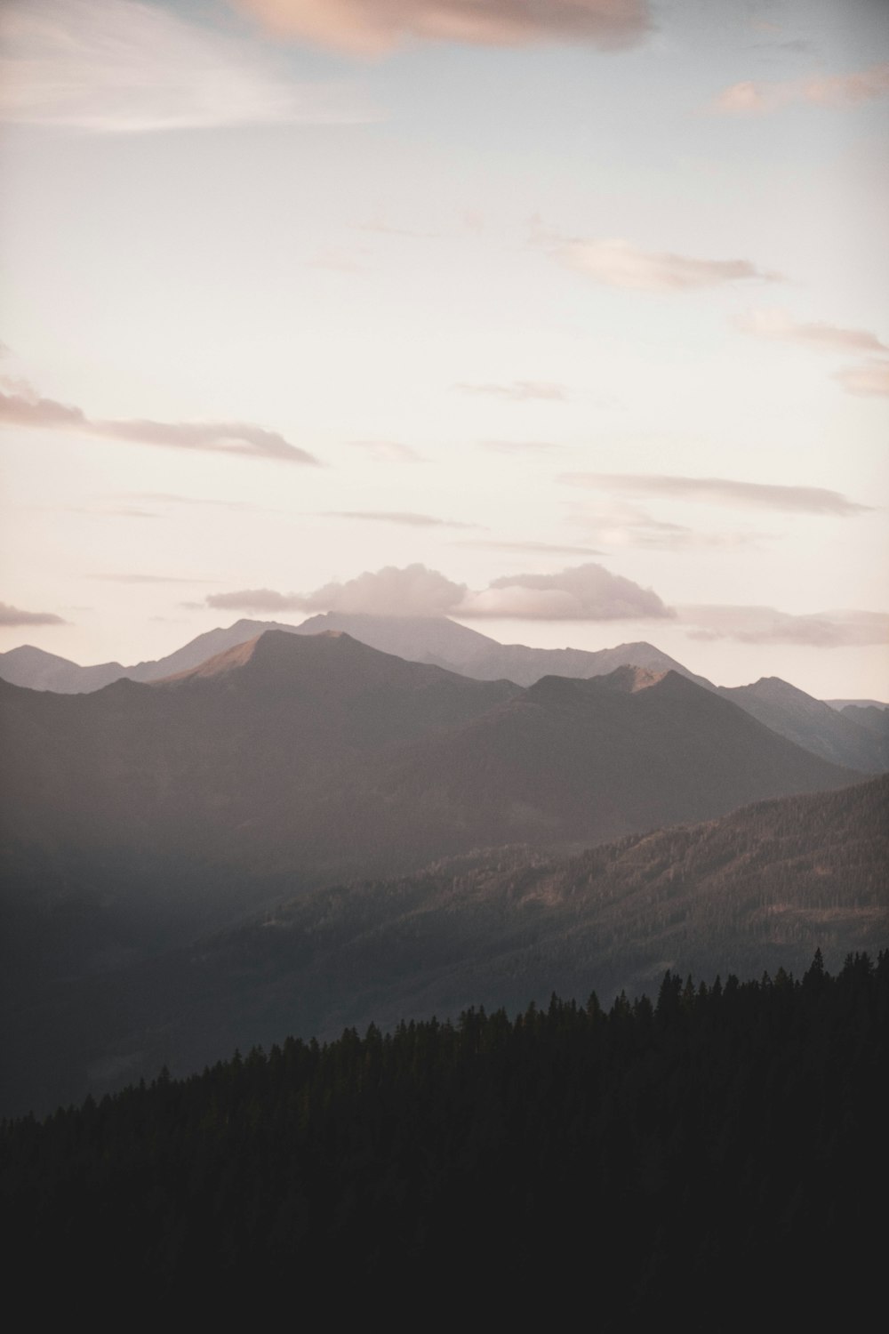 a view of a mountain range with trees in the foreground