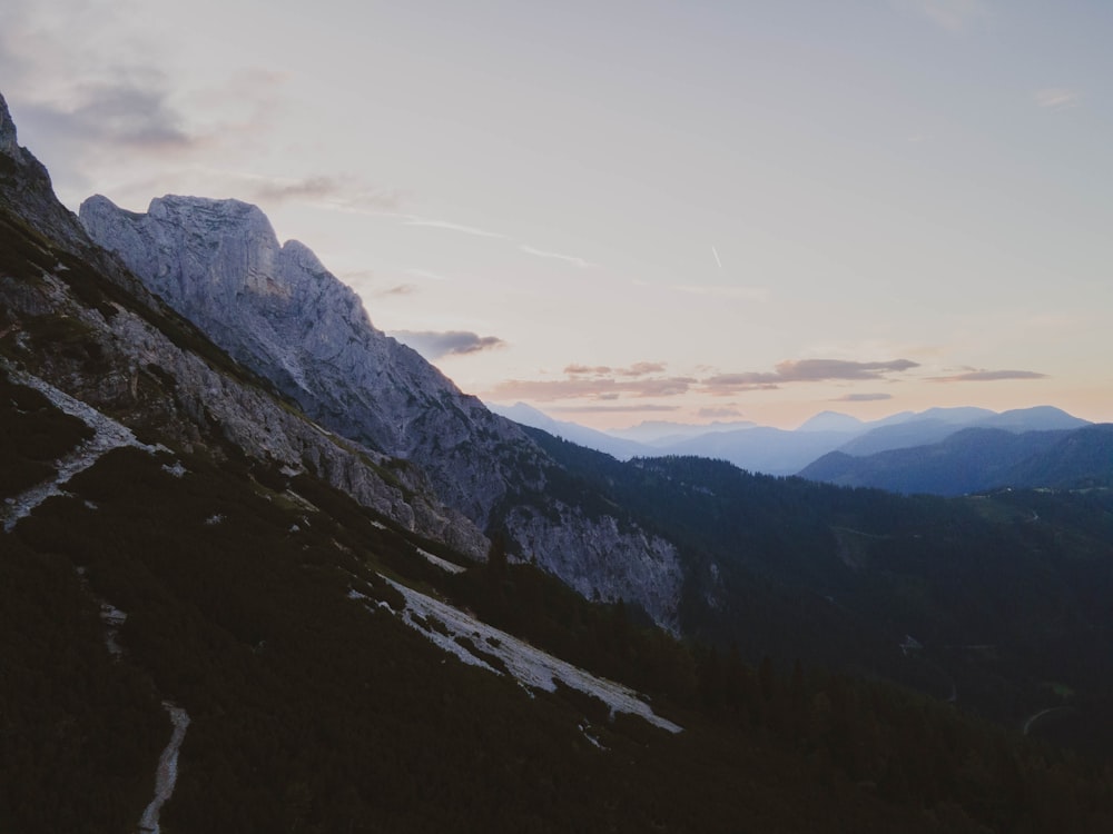 the sun is setting on a mountain side