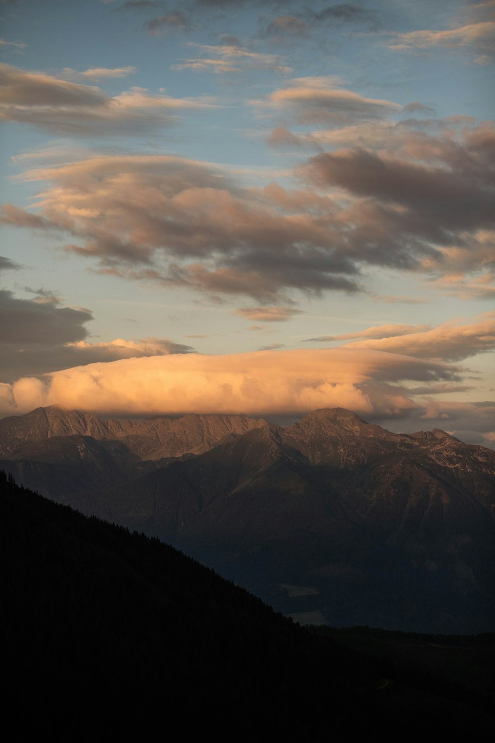 a view of a mountain range with clouds in the sky