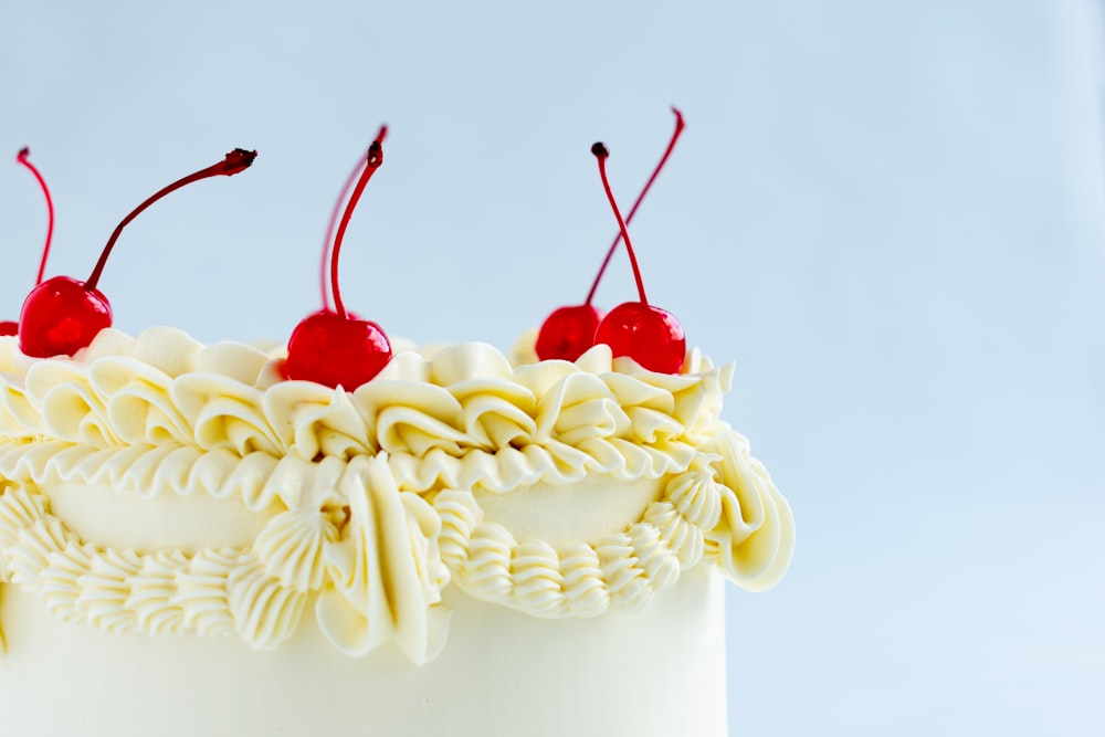 a close up of a cake with cherries on top