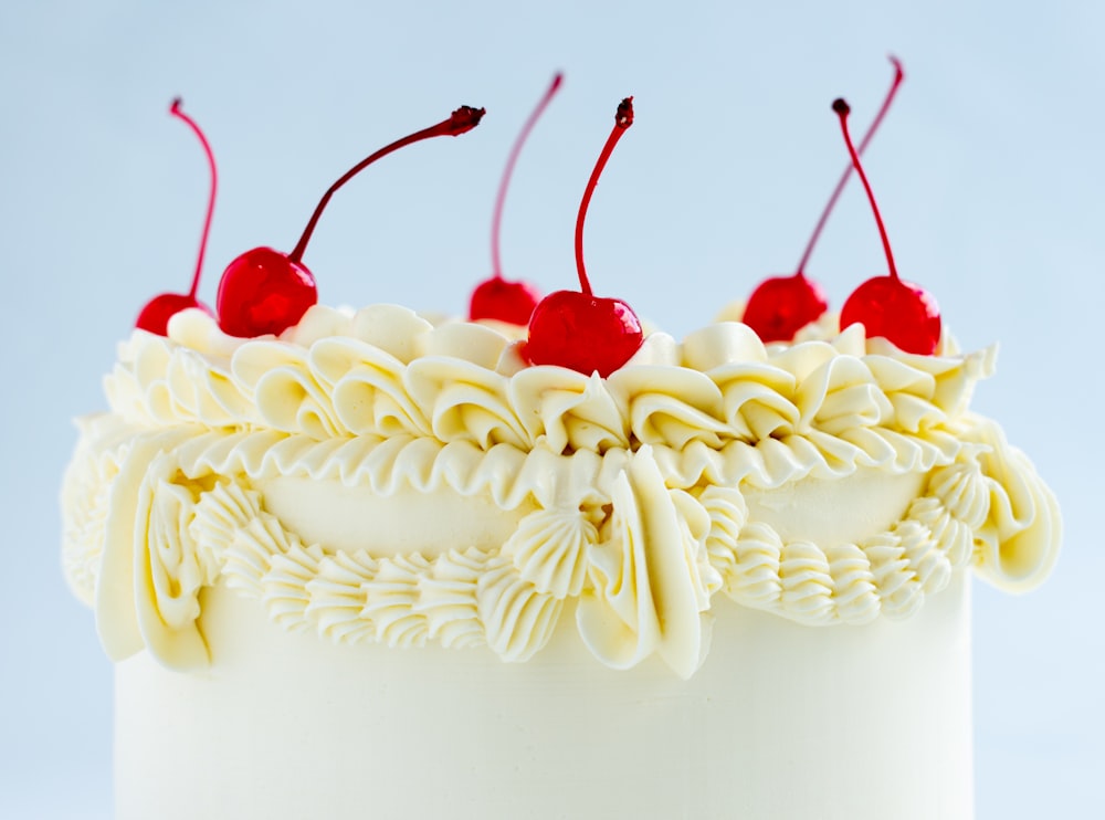 um close up de um bolo com cerejas por cima