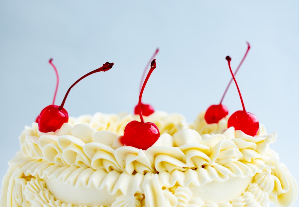 a close up of a cake with cherries on top