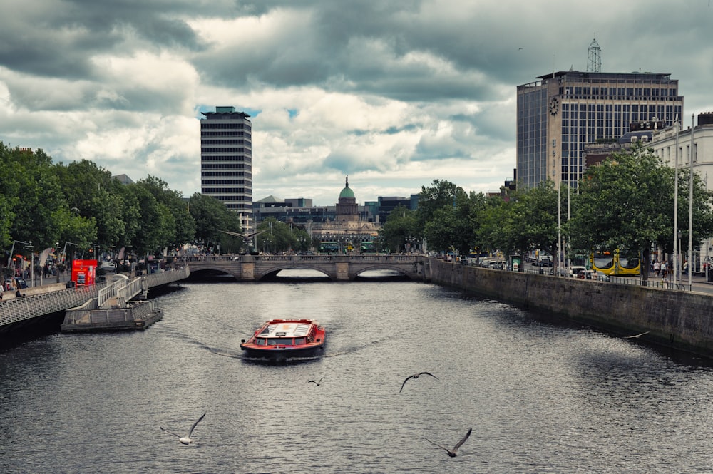 a boat traveling down a river next to tall buildings