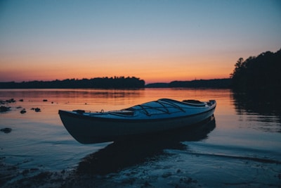 A kayak resting on the lake’s edge ready for a tranquil paddle at dawn.
