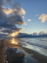 A scenic beach view with golden sands and gentle waves at sunset in Goa.