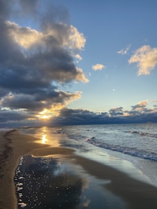 A scenic beach view with golden sands and gentle waves at sunset in Goa.