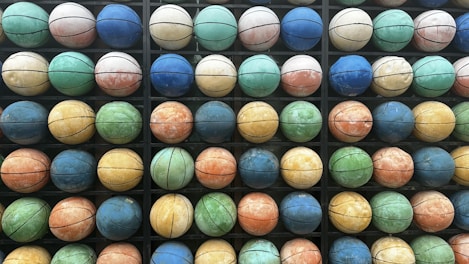 A collection of colorful basketballs arranged on a gym floor.