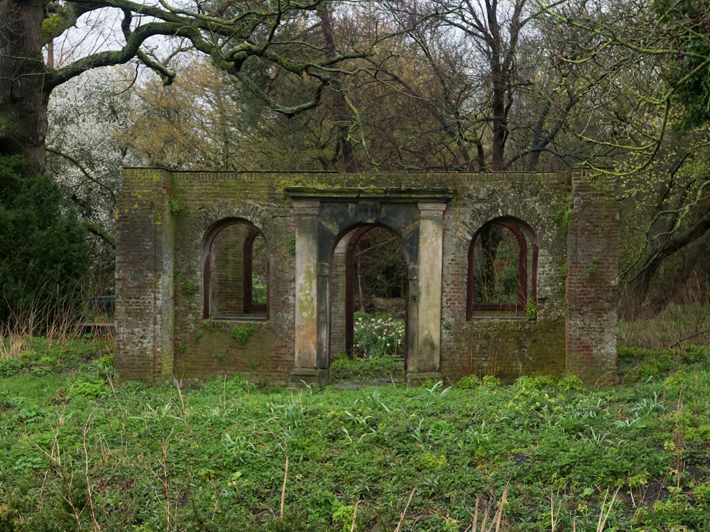 an old brick building in the middle of a forest