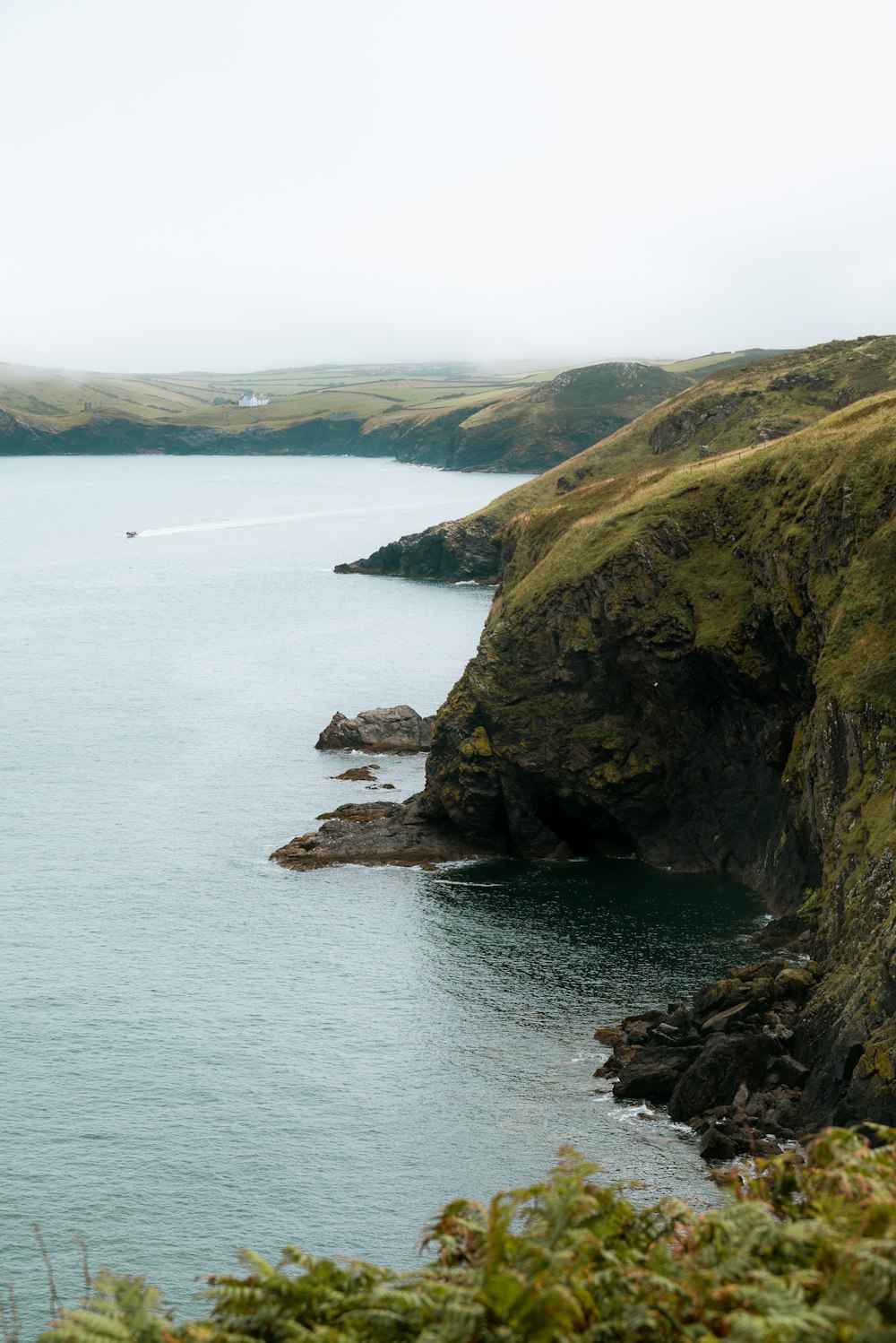 a large body of water surrounded by lush green hills