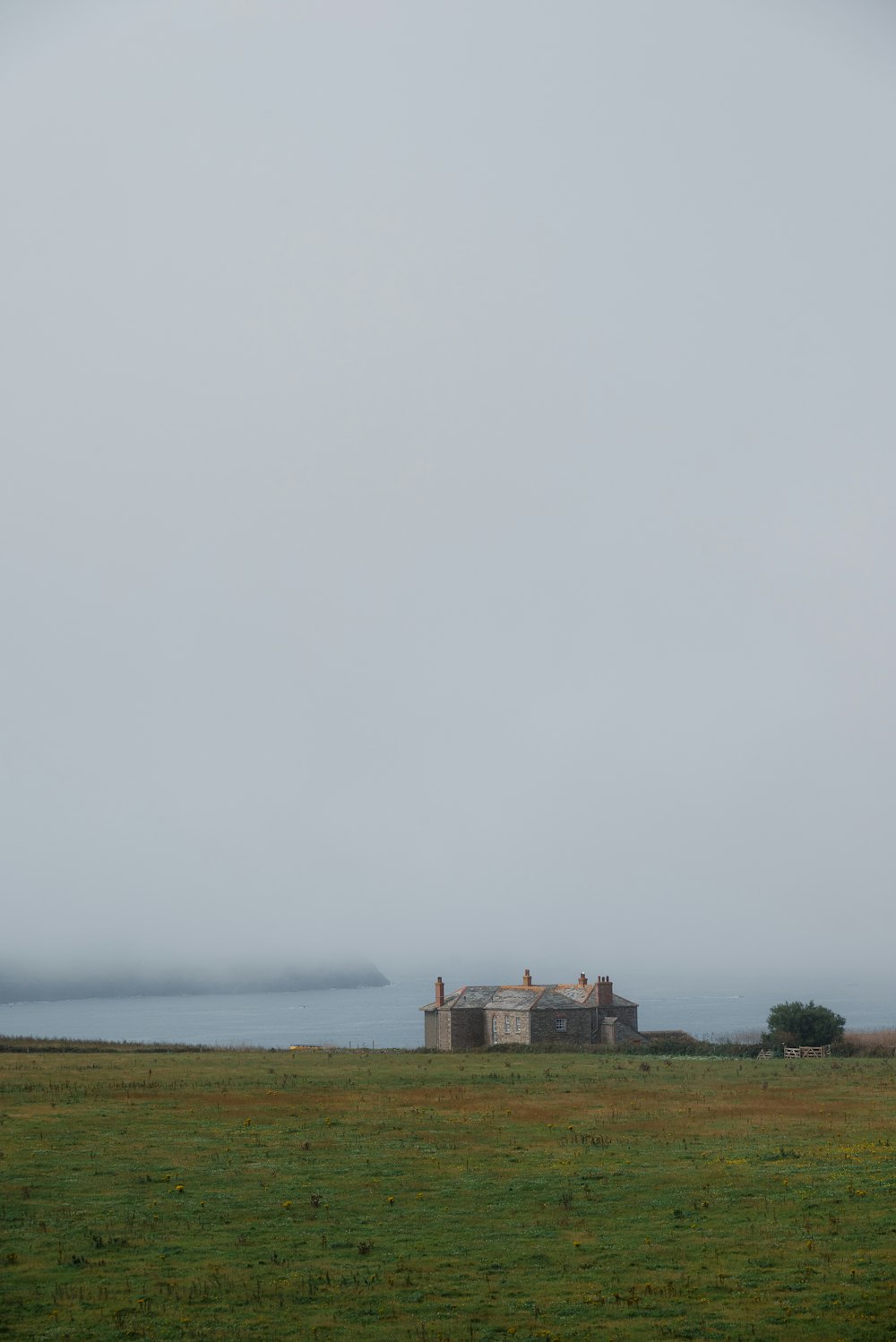 a large field with a house in the distance