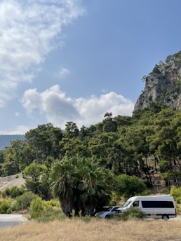 Lush Guanacaste landscape with a comfortable shuttle van parked on a sunny roadside.