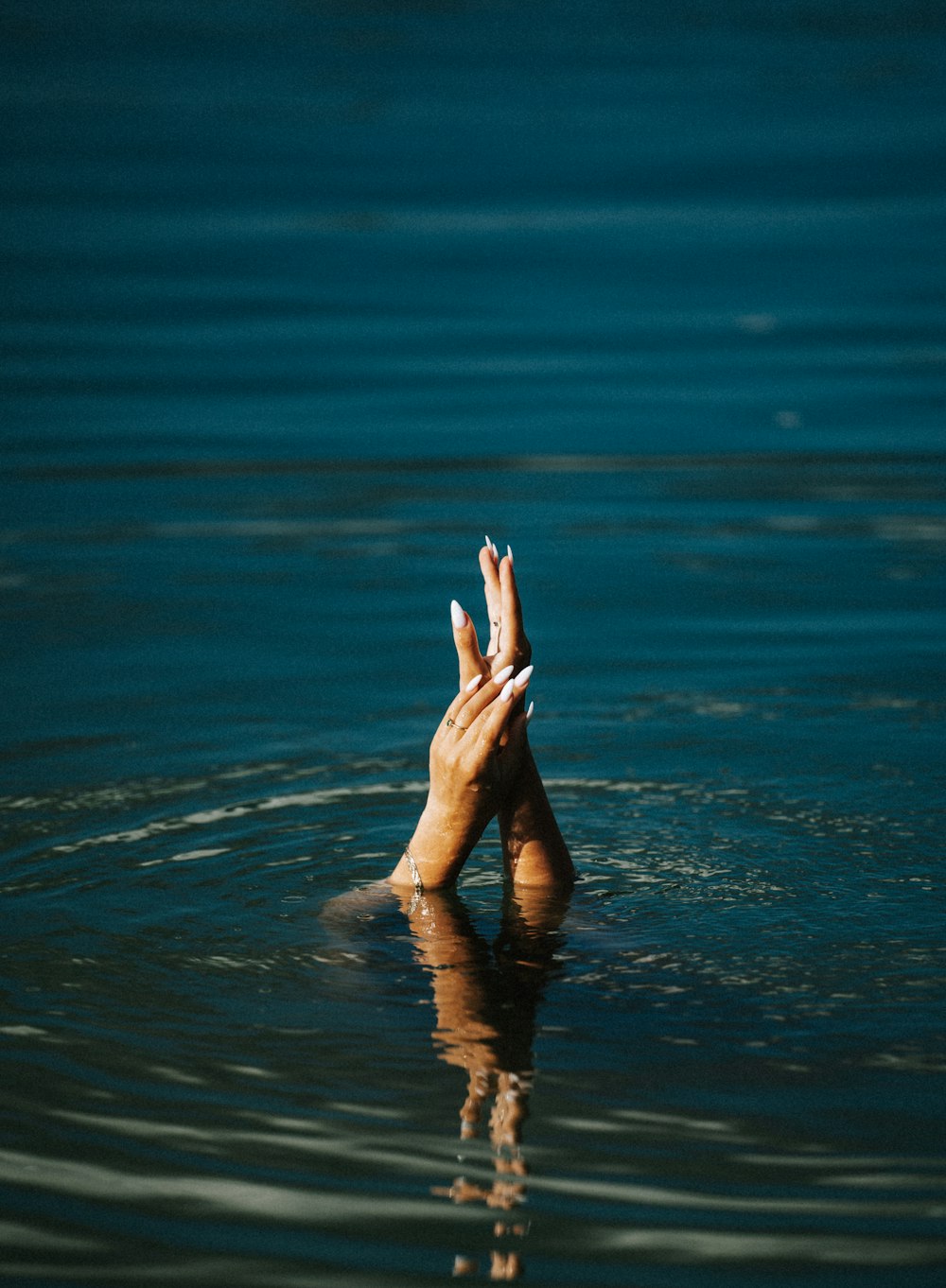 una persona che tiene le mani in alto nell'acqua