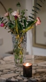 An elegant outdoor setting with a rose gold vase holding vibrant seasonal blooms on a marble surface.