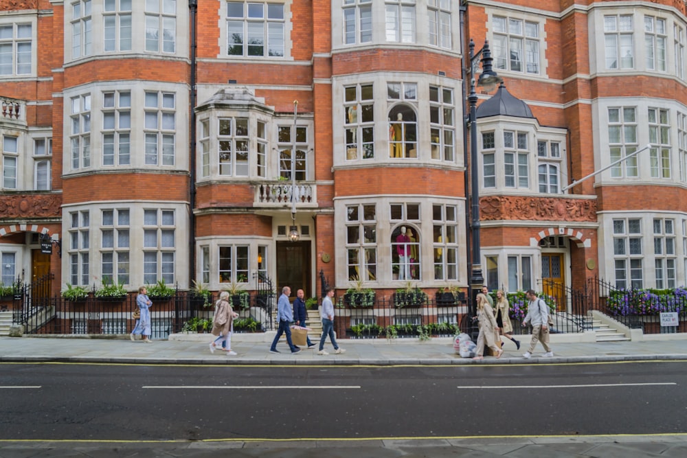 a group of people crossing a street in front of a building