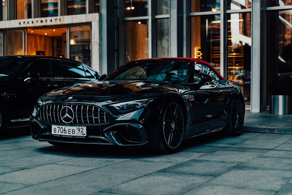 a black mercedes sports car parked in front of a building