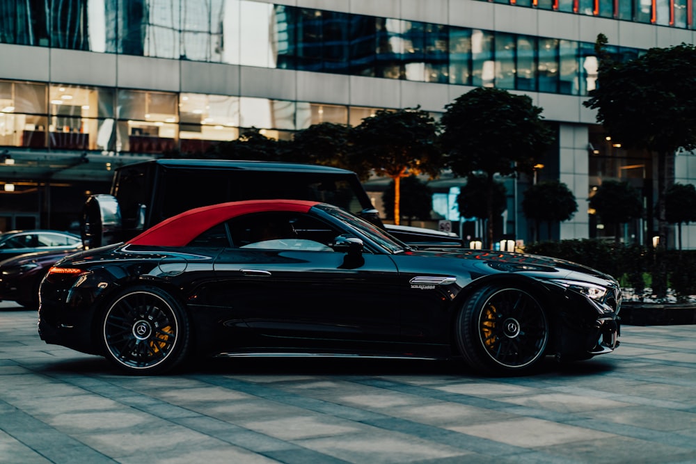 a black sports car parked in front of a tall building