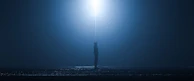 Silhouette of a person standing under a flickering streetlamp with a smoky atmosphere.