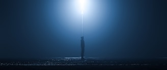 A shadowy figure standing under a flickering streetlamp on a foggy Memphis street at night.