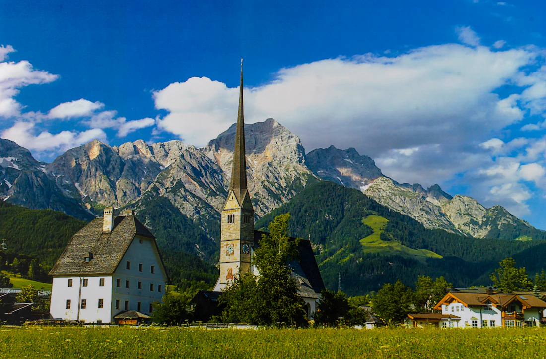 De kerk van Maria Alm met zijn toren voor een bergketen