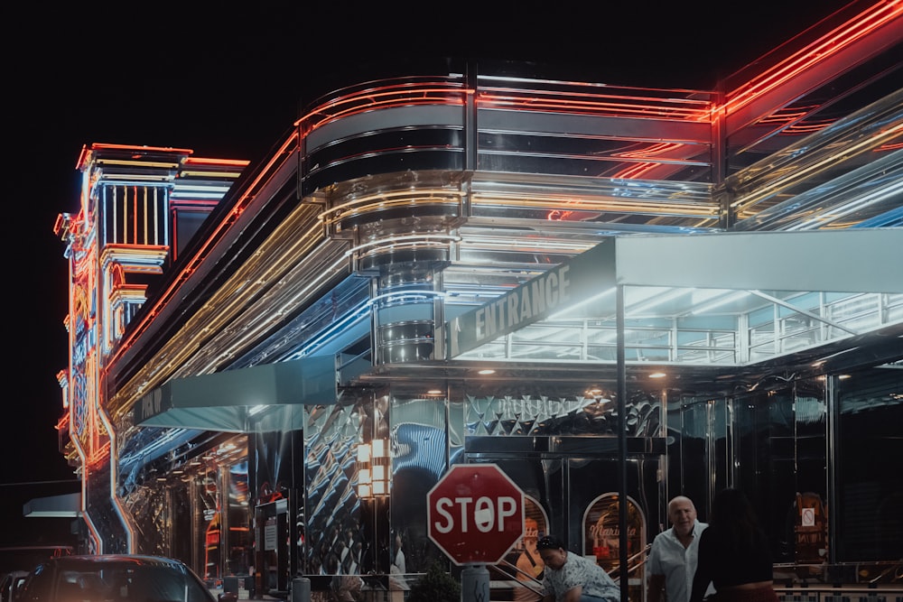 a group of people standing outside of a building at night