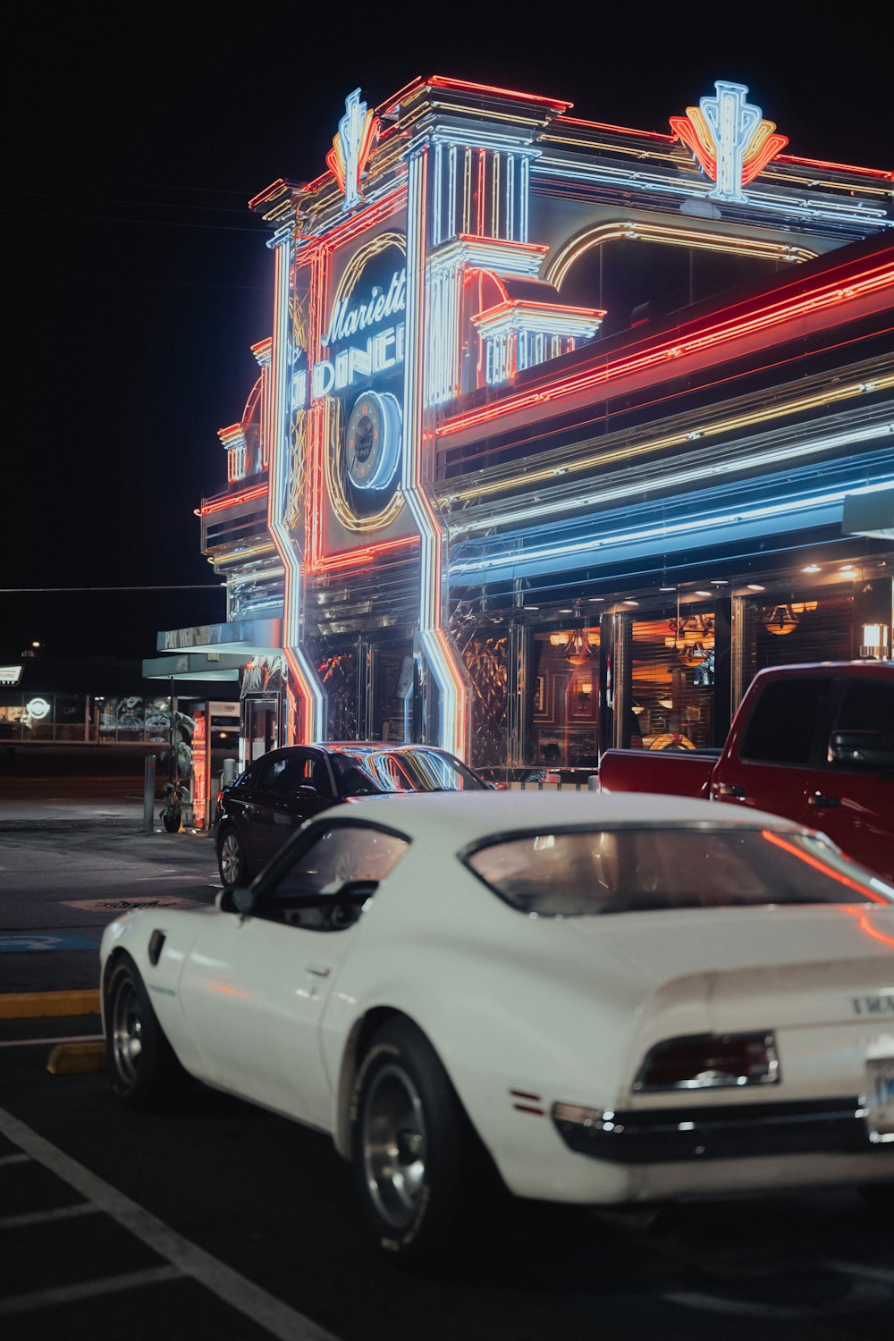 a car parked in front of a building with neon lights