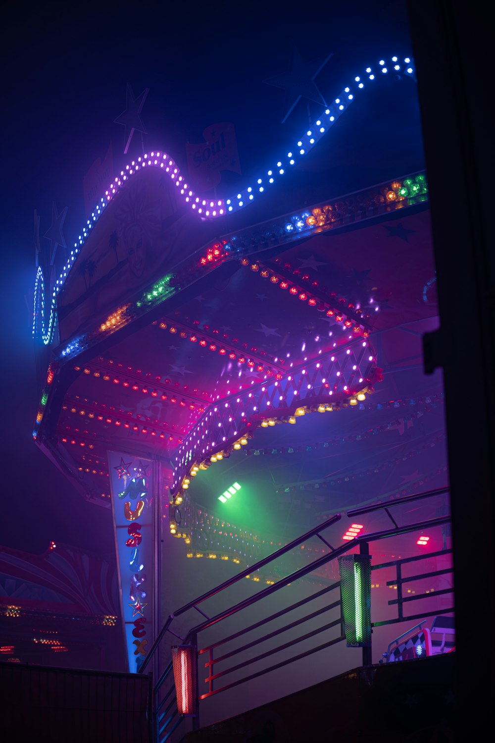 a carnival ride lit up at night with colorful lights