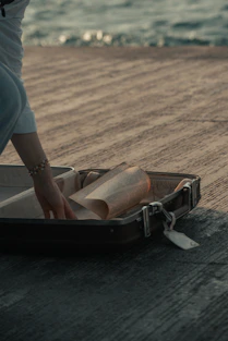 a person putting a roll of paper in a suitcase