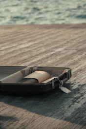 A scenic beach with a suitcase and travel tickets laid out on a wooden table