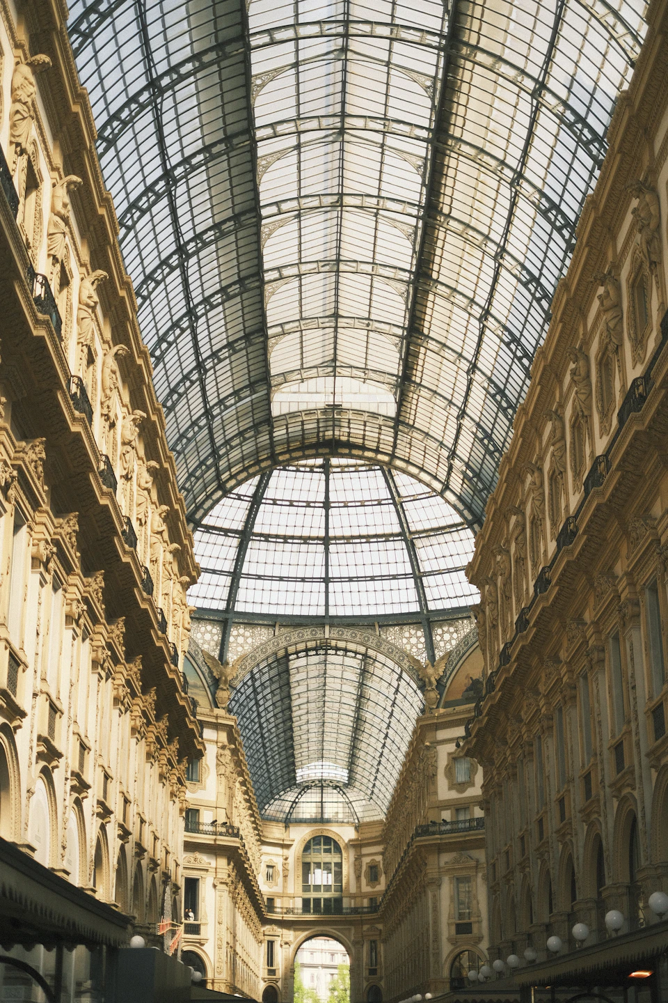 Grand, ornate building with high arched windows and intricate details under glass ceiling