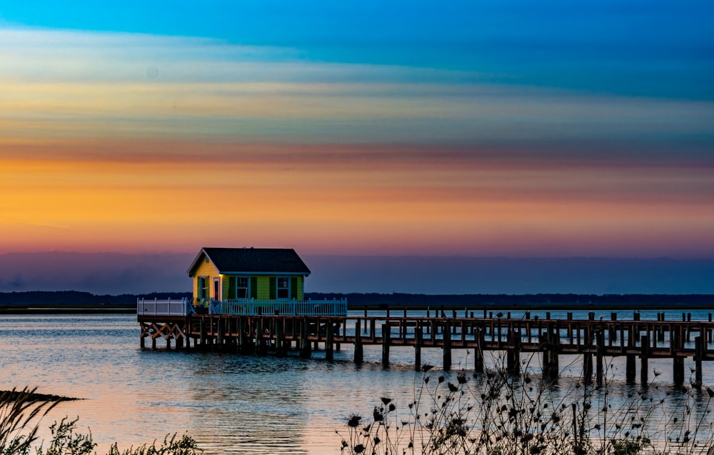 a small house sitting on top of a wooden pier