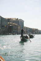 Elegant gondola gliding through Venice’s shimmering canals under historic bridges.