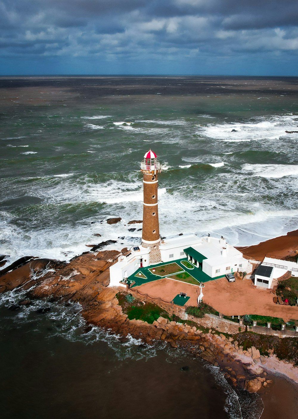 an aerial view of a lighthouse in the middle of the ocean