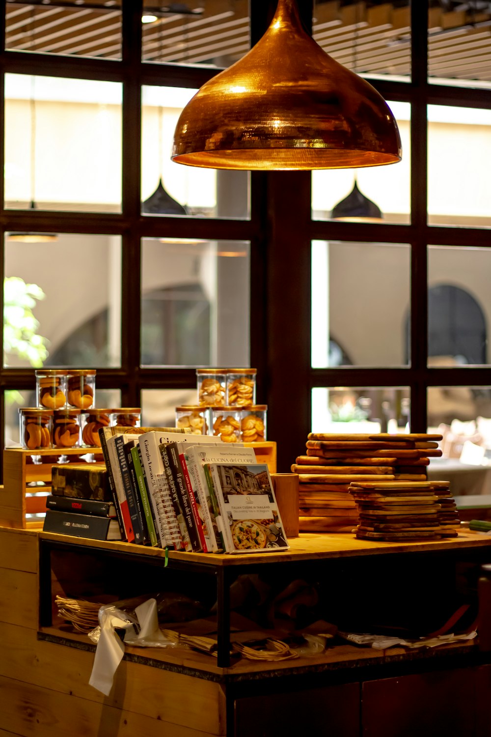 a table with books and a lamp hanging over it