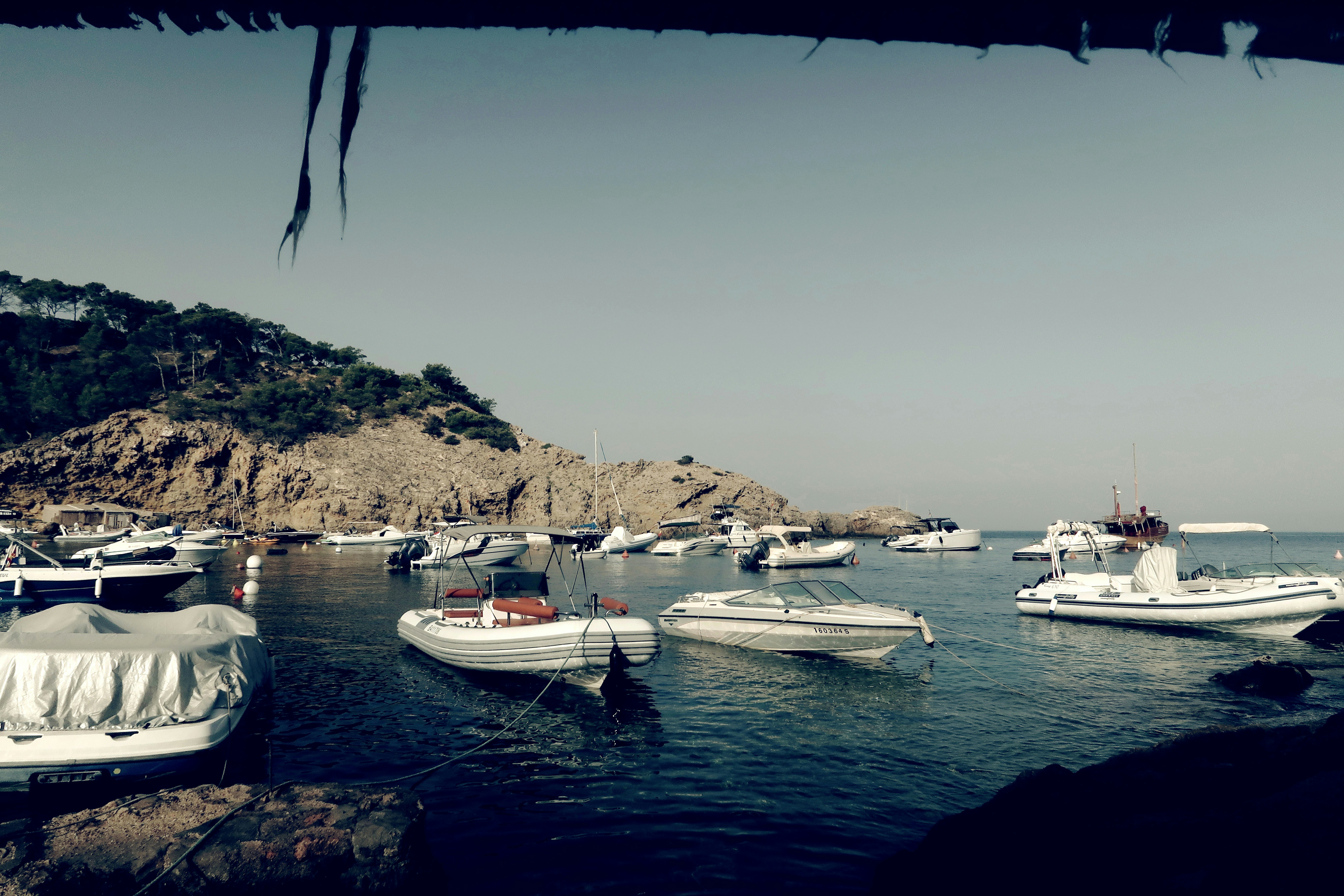 a group of boats floating on top of a body of water, Mediterranean cove
