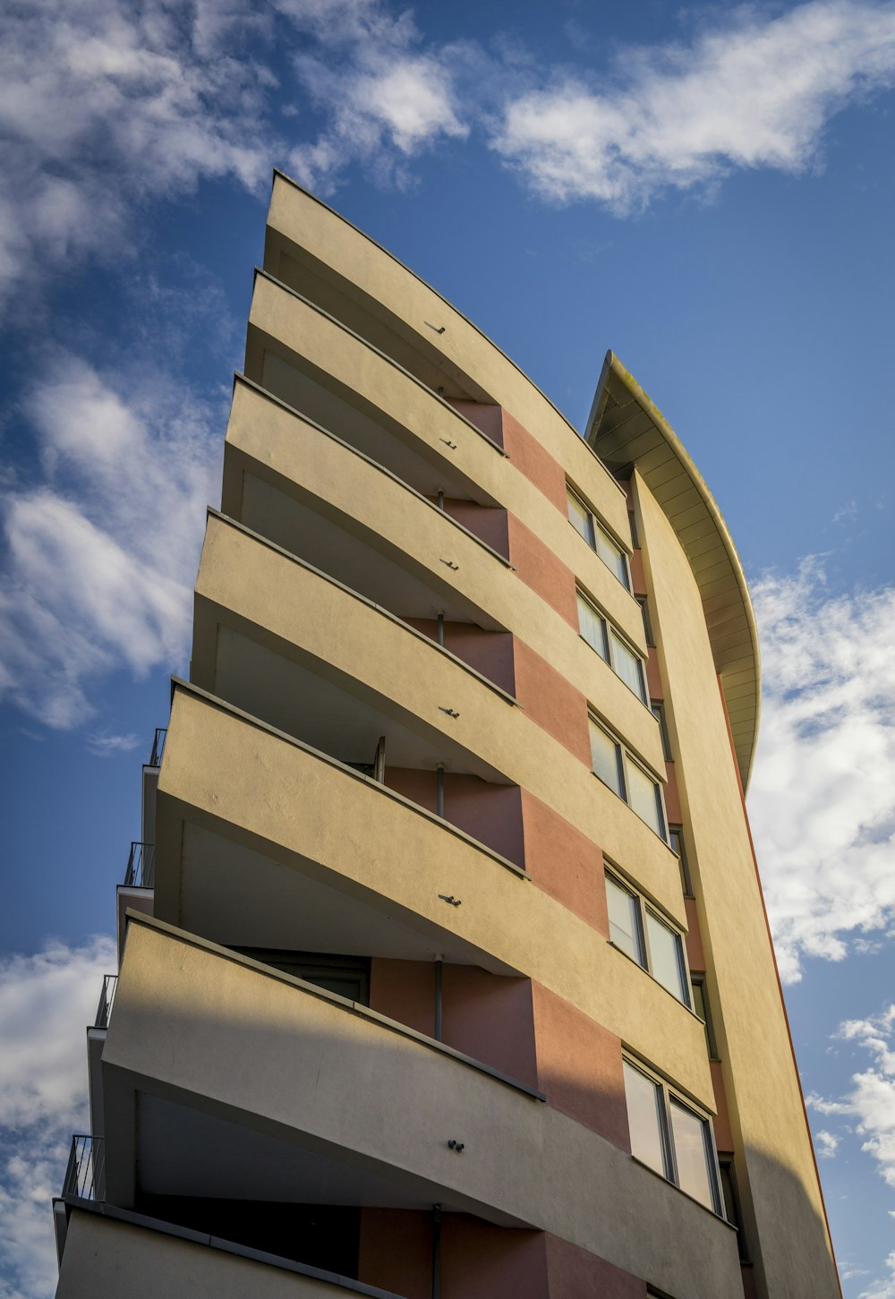 a tall building with balconies against a blue sky