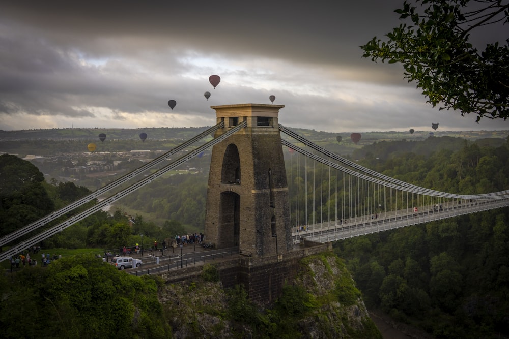 a bridge with hot air balloons flying over it