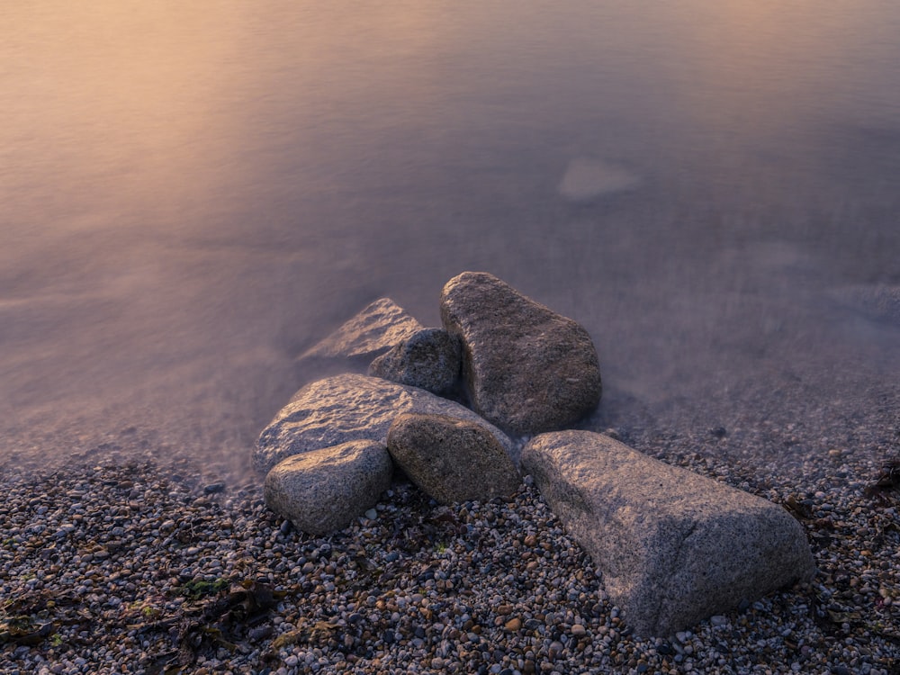 a group of rocks sitting on top of a beach