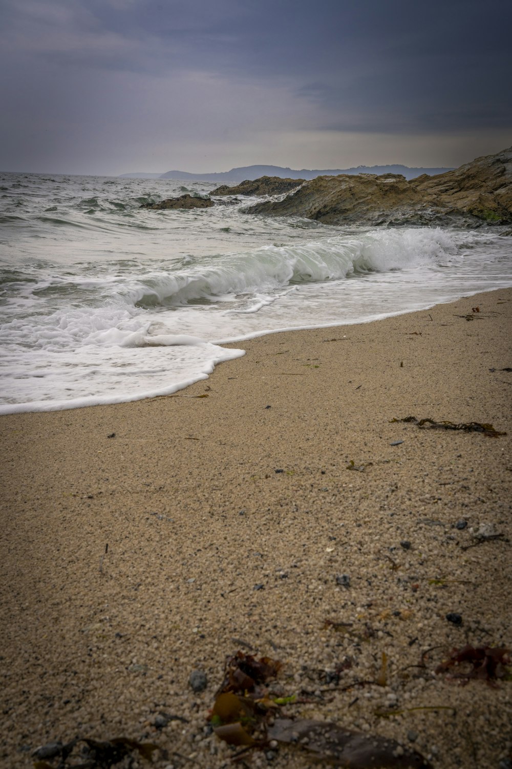 a sandy beach with waves coming in to shore