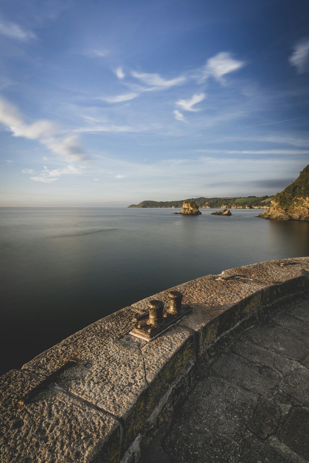 a stone wall overlooks a body of water