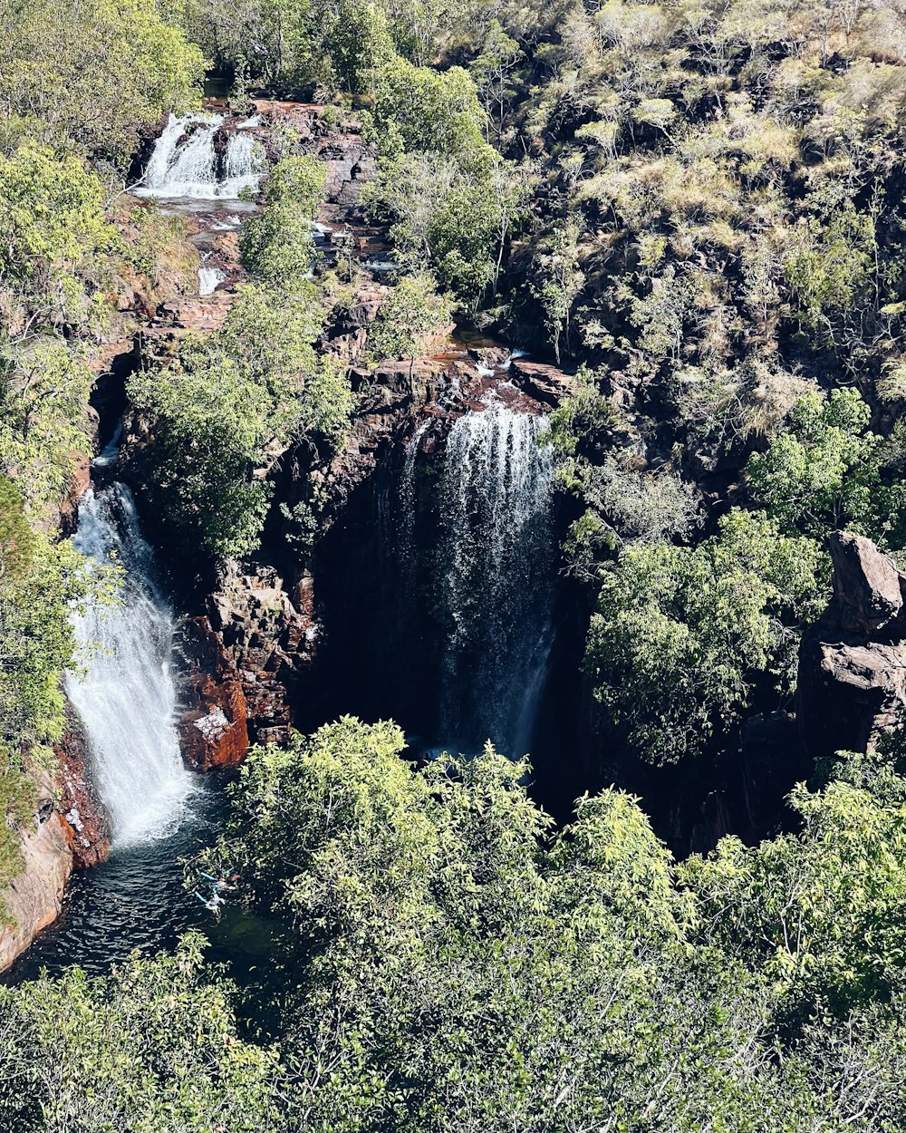 an aerial view of a waterfall surrounded by trees